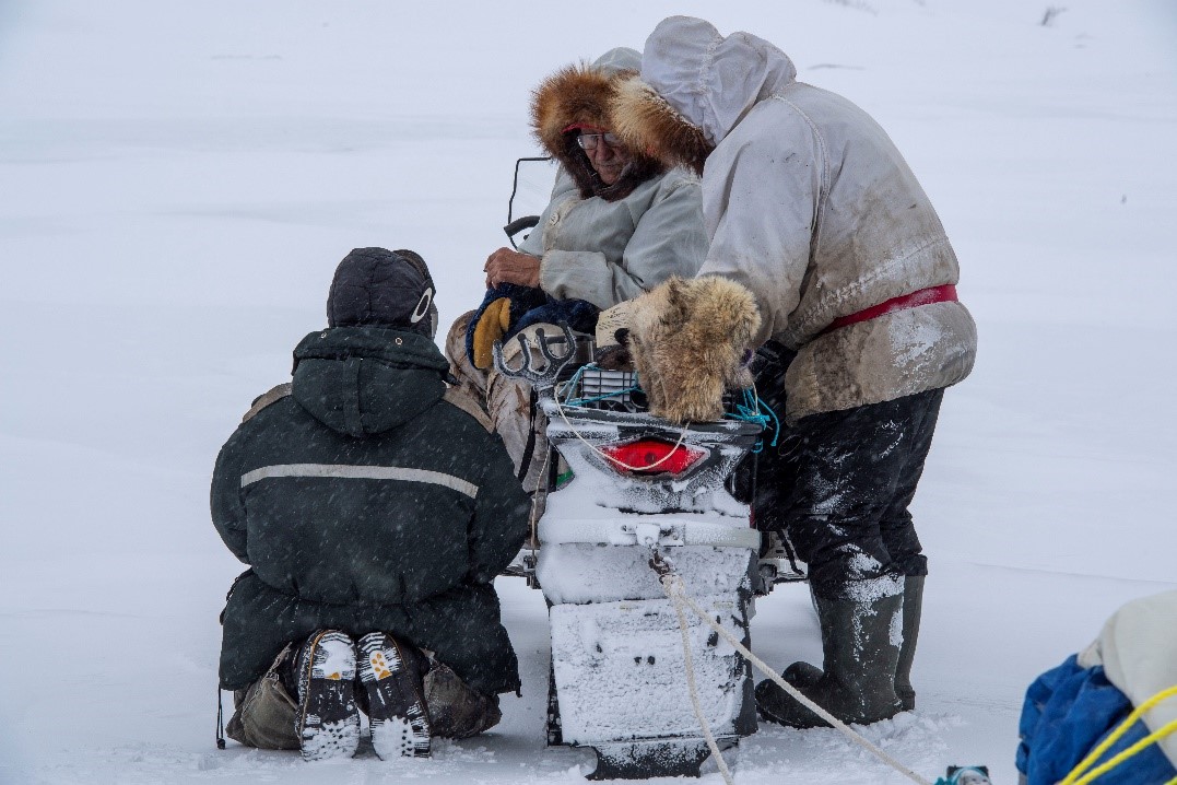 Soldiers loading a snow mobile with baggage.