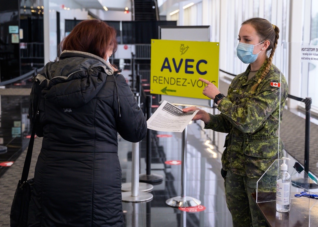 Soldier directing a customer at a vaccination center.