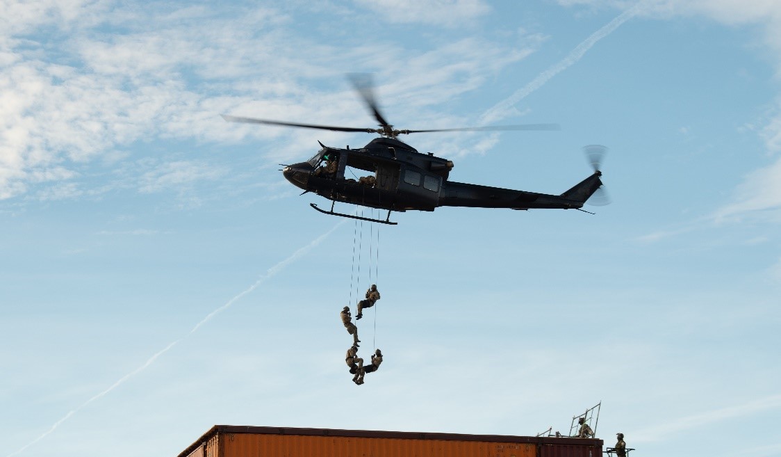 Special Operations members repelling from a helicopter.