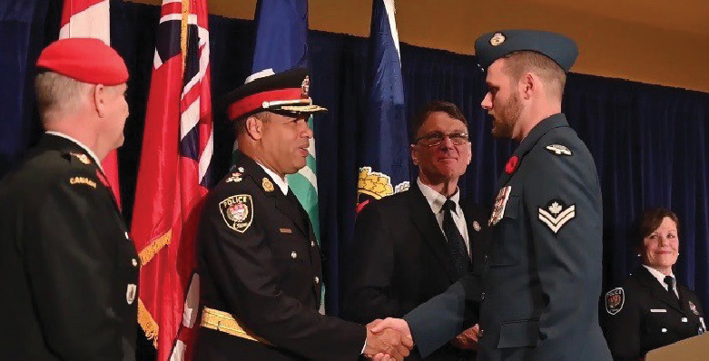 Un agent de la police militaire serre la main du chef de la police d'Ottawa Peter Sloly.