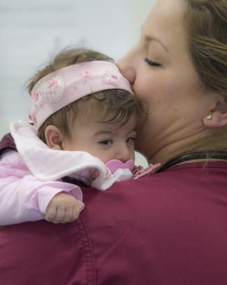 Master Corporal Sandra Eis holds an infant