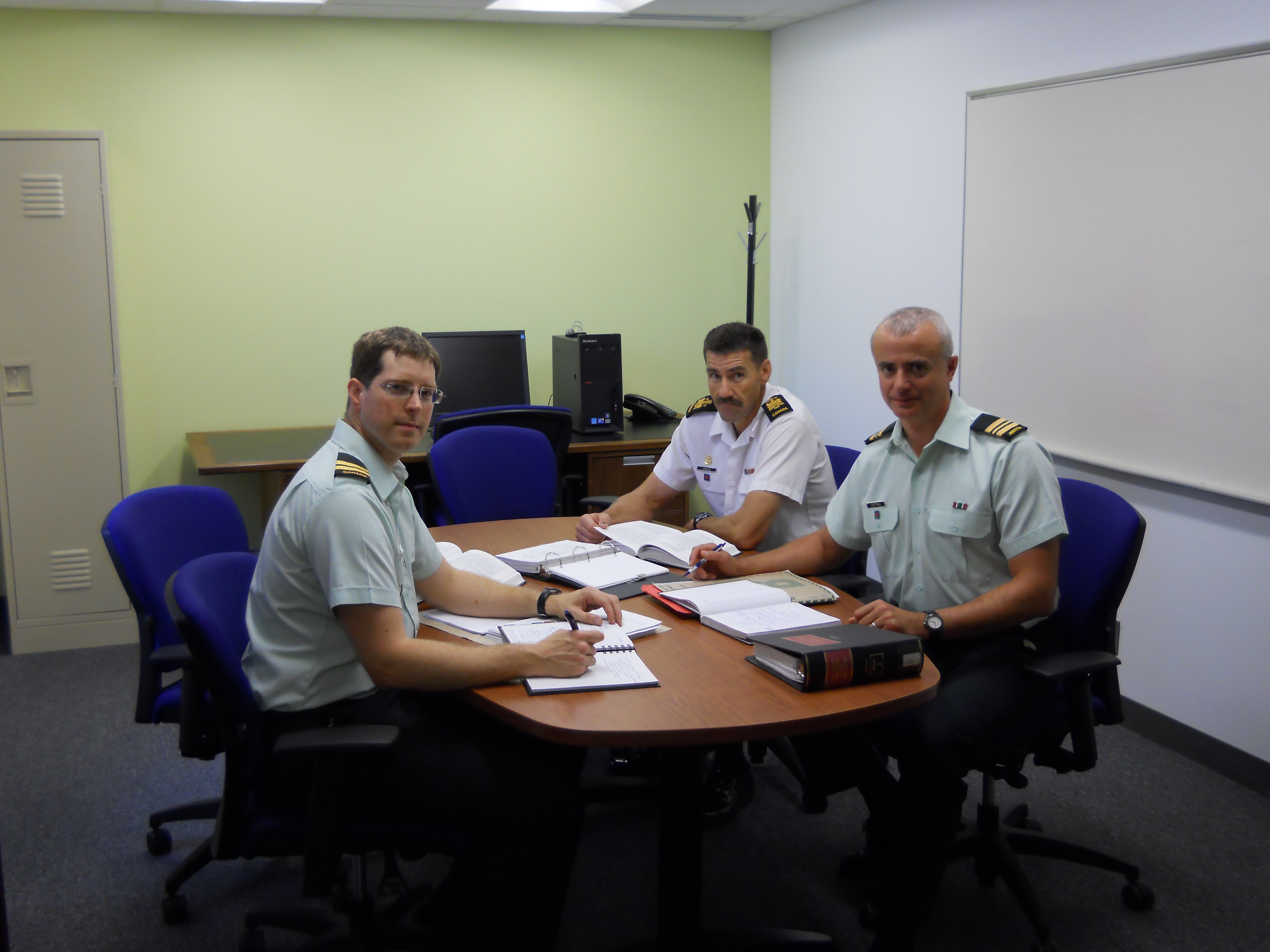 Three legal officers in a meeting.