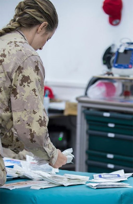 Une infirmière des Forces armées canadiennes prépare le matériel médical à l’installation médicale de rôle 2 au cours de l’opération IMPACT