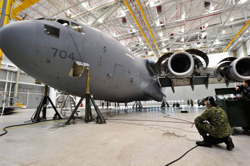 November 19, 2012, aviation Systems Technician Corporal Chance Trevor is in constant communication with an other technician in the airplane cockpit while conducting checks on landing gear during a periodical maintenance called Home Station Check. Canadian Forces Combat Camera photo by : Sgt Gaétan Racine