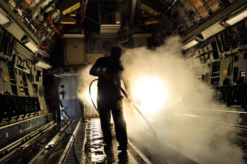 Aircraft Structures Technician Corporal Michael Glennon uses steam to clean a CC-177 floor during a Home Station Check (HSC). Photo: Sgt Gaétan Racine, Canadian Forces Combat Camera