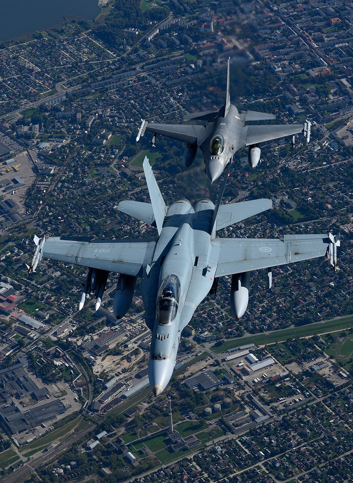 A CF-18 Hornet from the Canadian Air Task Force Lithuania flies with a Portuguese F16 Fighting Falcon over Lithuania on September 15, 2014 for the NATO Baltic Air Policing Block 36 during Operation REASSURANCE.