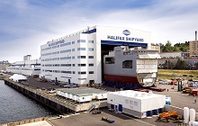 L’un des mégablocs du futur NCSM Harry DeWolf est transporté à l’extérieur de l’immense hangar du chantier naval de Halifax (juillet 2017).