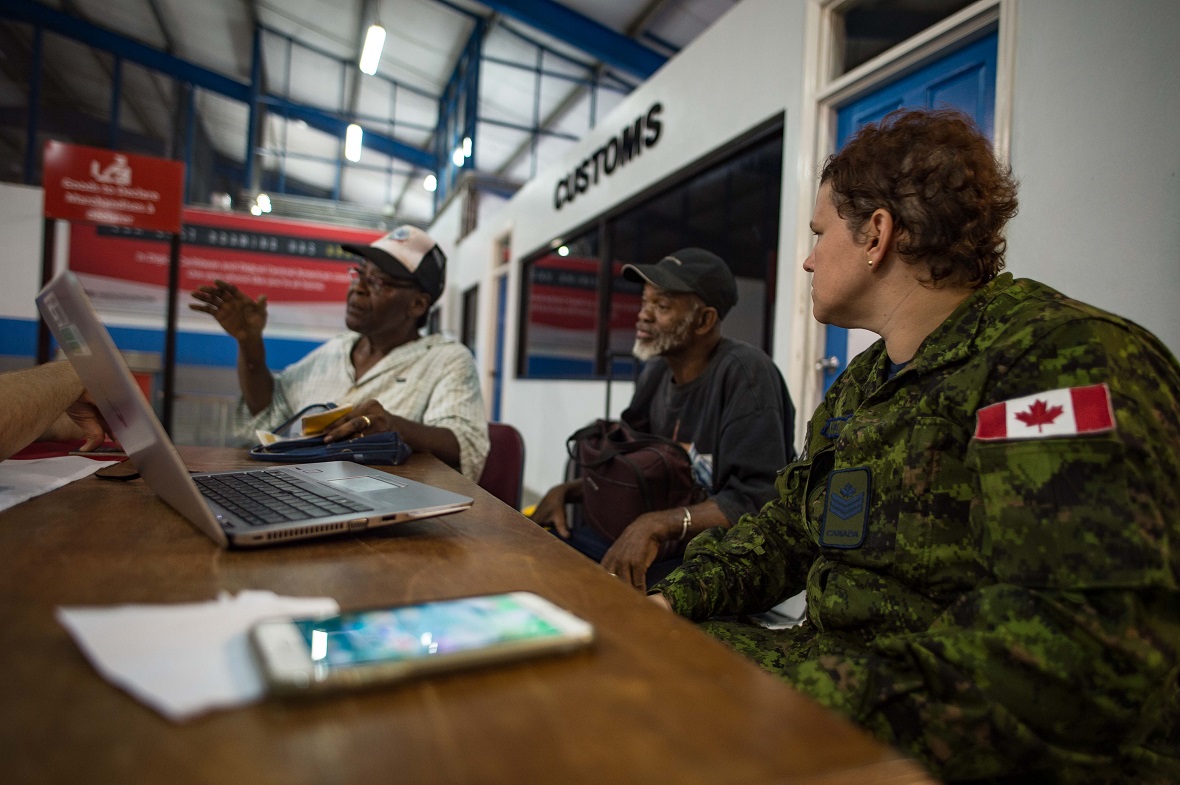 Sergeant Melissa Farrell listens to a couple of Canadian refugees coming from the island of Dominica, talking about their experience after Hurricane Maria, at the port in St. Lucia, in the Caribbean, September 23, 2017. Photo: Corporal Gary Calvé, Imagery Technician, ATF RENAISSANCE.