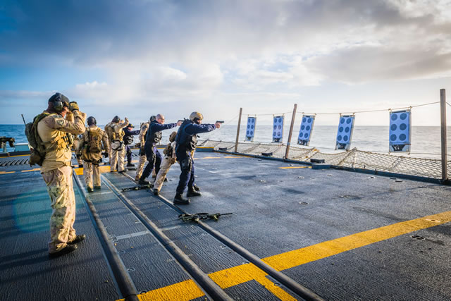 L’équipe spéciale du Groupe des opérations tactiques maritimes (GOTM) et des membres de l'équipe d'arraisonnement des navires de la Marine royale canadienne s'exercent au pistolet sur le pont d'envol du Navire canadien de Sa Majesté (NCSM) St. John's dans le cadre de l'opération REASSURANCE, au large de la Norvège, le 21 février 2018. Photo : Caporal Tony Chand, Services d’imagerie de la formation RP17-2018-0028-02569