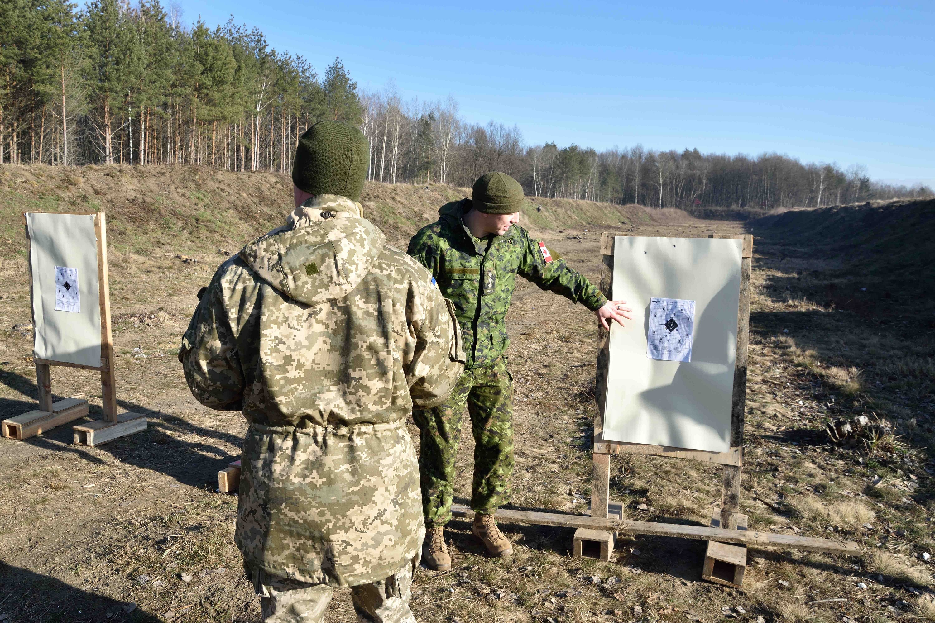 A Canadian Armed Forces trainer from Joint Task Force-Ukraine mentors a member of the Ukrainian Rotational Training Unit on personal weapons drills on a range during Operation UNIFIER at the International Peacekeeping and Security Centre in Starychi, Ukraine on January 31, 2018. Photo: Joint Task Force - Ukraine 