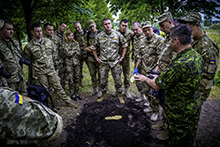 ak51-2016-59-003 July 21 2016. Ukrainian Armed Forces (UAF) assistant instructor, Major Onipko, stands surrounded by UAF students as trainees as a Canadian Military Police Instructor explains the technique of footprint casting during the Canadian led Military Police Investigator Course in Kyiv, Ukraine as part of Operation UNIFIER, on the 21st of July, 2016. (Photo: Joint Task Force Ukraine) 