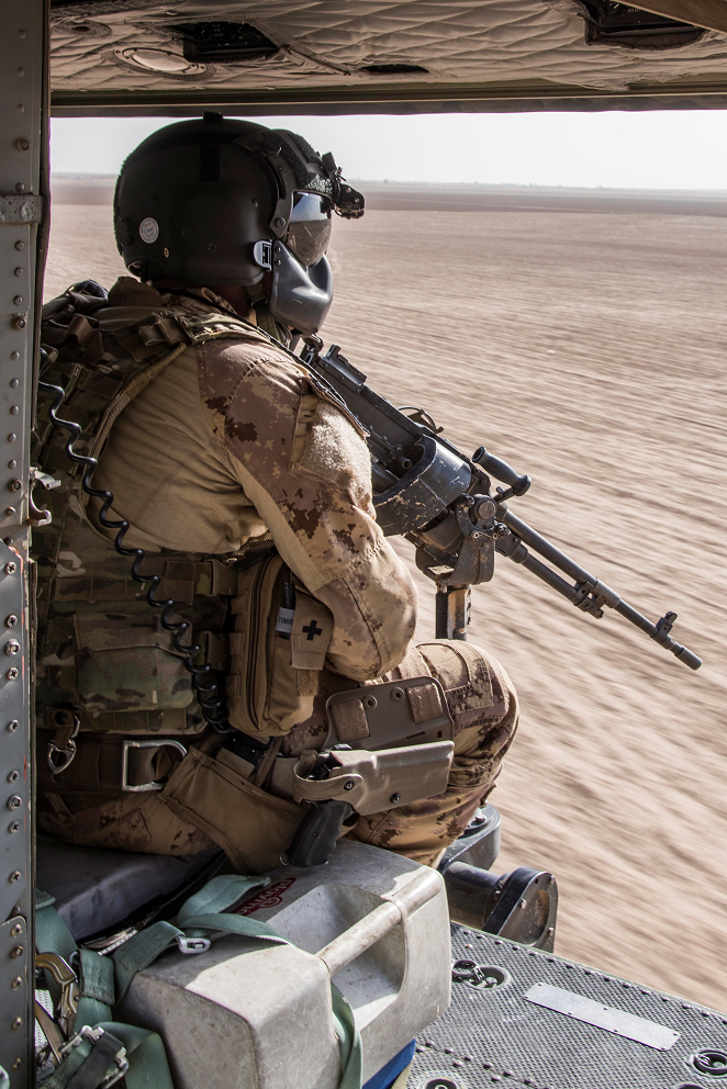 A door gunner with the Tactical Aviation Detachment watches out of a CH-146 Griffon helicopter during Operation IMPACT on September 27, 2017. Photo: Op IMPACT, DND