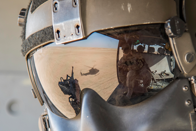 Image du reflet de la visière du casque d' un mitrailleur de porte à bord d`un hélicoptère.