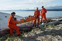 September 14, 2015. Search and Rescue Technicians Master Corporal Ashley Barker (left) and Master Corporal Jeff Connors with 413 Squadron from 14 Wing Greenwood, move a casualty to a safe location while exercise evaluators keep watch, during a medical event as part of SAREX 15, in Comox, British Columbia on September 14, 2015. (Photo: Corporal Ian Thompson, Imagery Technician, 4 Wing Cold Lake AB)