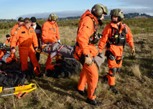 Comox, British Columbia, 22 November 2013 – Search and Rescue Technicians prepare to evacuate a victim of a mock aircraft crash site for an exercise. (Photo by: Cpl Jennifer Chiasson)