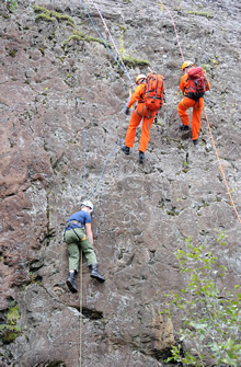 Val-d’Or, Quebec. 17 September 2012 – Search and Rescue technician, Master Corporal Marco Journeyman (centre), from 424 Transport and Rescue Squadron in Trenton, Ontario and scenario supervisor, Sergeant Bill Kelland, from The Canadian Forces School of Search and Rescue in Comox, British Columbia, repel down a rock face to rescue a stranded mock casualty during the National Search and Rescue Exercise (SAREX) 2012 near Val-d’Or, Quebec. (Photo by: Sergeant Matthew McGregor, Canadian Forces Combat Camera © 2012 DND-MDN Canada)
