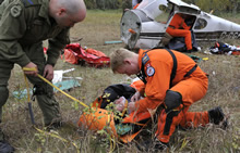 Gimli, Manitoba. 19 September 2013 – Corporal Jason Kennedy (left) and Master Corporal Curtis Schmidt (right) attend to a simulated casualty during the 2013 National Search and Rescue Exercise. (Photo by Darryl Hepner, 17 Wing Winnipeg)