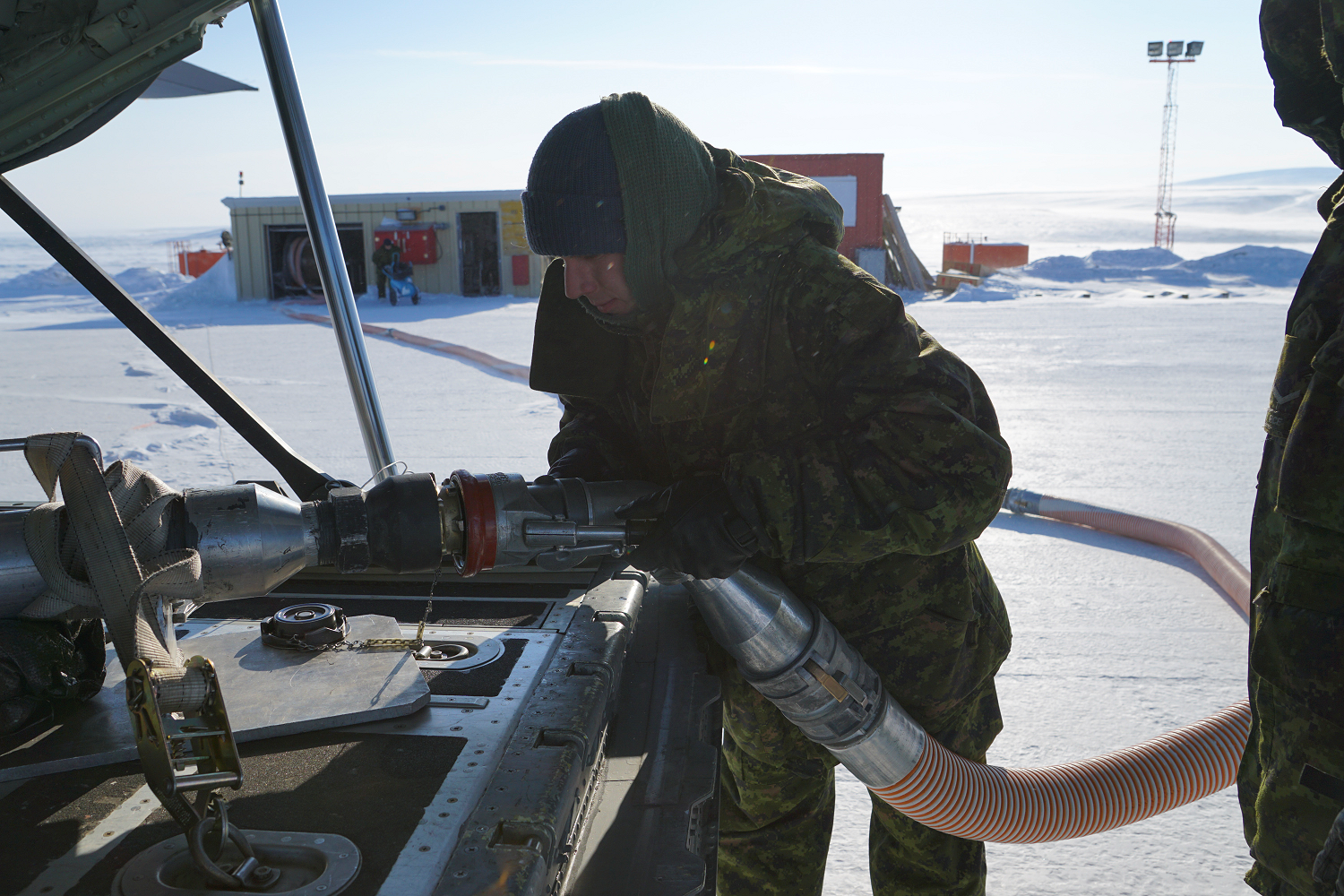 April 21, 2015. MCpl Frank Charest from CFB Comox and Pte Mathew Lloyd of CFB Greenwood ensure that the fuel hoses are safely connected before fuel is extracted during Operation BOXTOP at Canadian Forces Station Alert, Nunavut on April 21, 2015. (Photo: Cpl Raymond Haack)