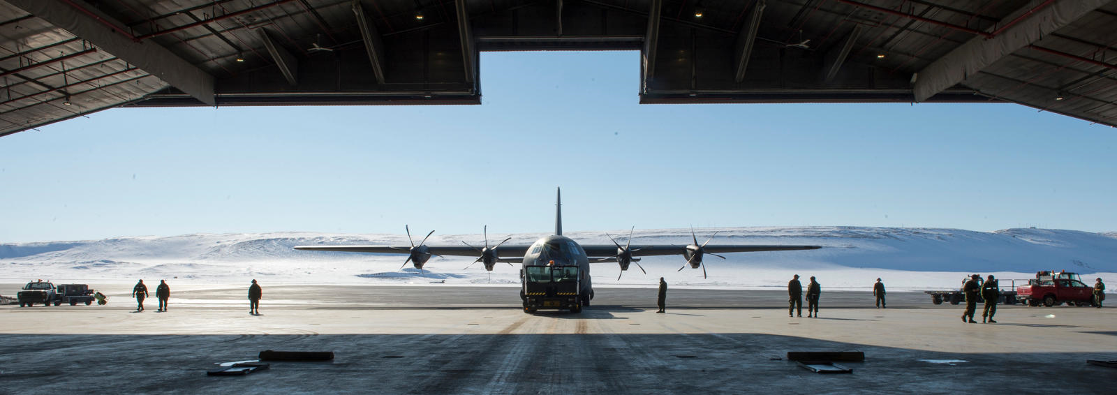 A CC-130 Hercules aircraft is towed into the hangar in Thule, Greenland during Operation BOXTOP on April 24, 2017. (Photo: Corporal Audrey Solomon, 8 Wing Imaging)