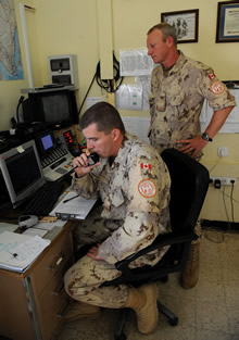 El Gorah, Egypt. 20 November 2008 – Corporal Kirby Walsh (left) communicates with an incoming aircraft as Sergeant Robert Frazier supervises at the air traffic control section on the Multinational Force and Observers (MFO) camp in El Gorah, Egypt. The air traffic controllers provide a flight following service, a task that involves receiving regular position reports from MFO aircraft, issuing traffic advisories and weather reports, and transmitting flight plans. (Photo by MCpl Robert Bottrill, Canadian Forces Combat Camera)