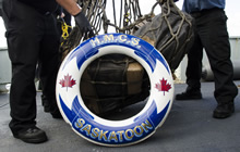 Des membres de l’équipage du Navire canadien de Sa Majesté Saskatoon chargent un filet d’arrimage avec des drogues illicites saisies le 13 mars 2017, afin de les transférer à un navire de la Garde côtière américaine pendant l’opération CARIBBE. Photo : Affaires publiques de la Marine royale canadienne