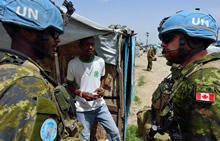 Port-au-Prince, Haiti. 10 September 2013 – Sergeant Pierre-Alexandre Ruegsegger (right) and Private Cedric Gelin speak with Internally Displaced Persons at camp Jean-Marie Vincent. (photo by: MCpl Marc-Andre Gaudreault, Canadian Forces Combat Camera)