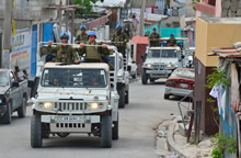 Port-au-Prince (Haïti). 10 septembre 2013 – Des soldats des Nations Unies issus du 2e Bataillon, Royal 22e Régiment patrouillent dans les rues de Port-au-Prince (Haïti) à bord de leur véhicule dans le cadre de l’opération Hamlet. (photo par Cplc Marc-André Gaudreault, Caméra de combat des Forces canadiennes)