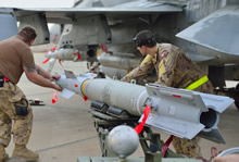 30 octobre 2014, Koweït – Une équipe au sol de l’Aviation royale canadienne aligne une bombe en chargeant les munitions sur un chasseur CF188 avant la première mission de combat au-dessus de l’Irak en soutien à l’opération Impact. (Photo IS2014-5022-07 par la Caméra de combat des Forces canadiennes)