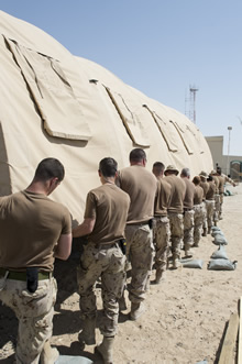 camp Patrice Vincent, au Koweït. Le 28 juin 2015 – Des membres des Forces armées canadiennes déplacent une tente lors de l’établissement du campement au camp Patrice Vincent, au Koweït, au cours de l’opération IMPACT. (Photo : Opération Impact, MDN)