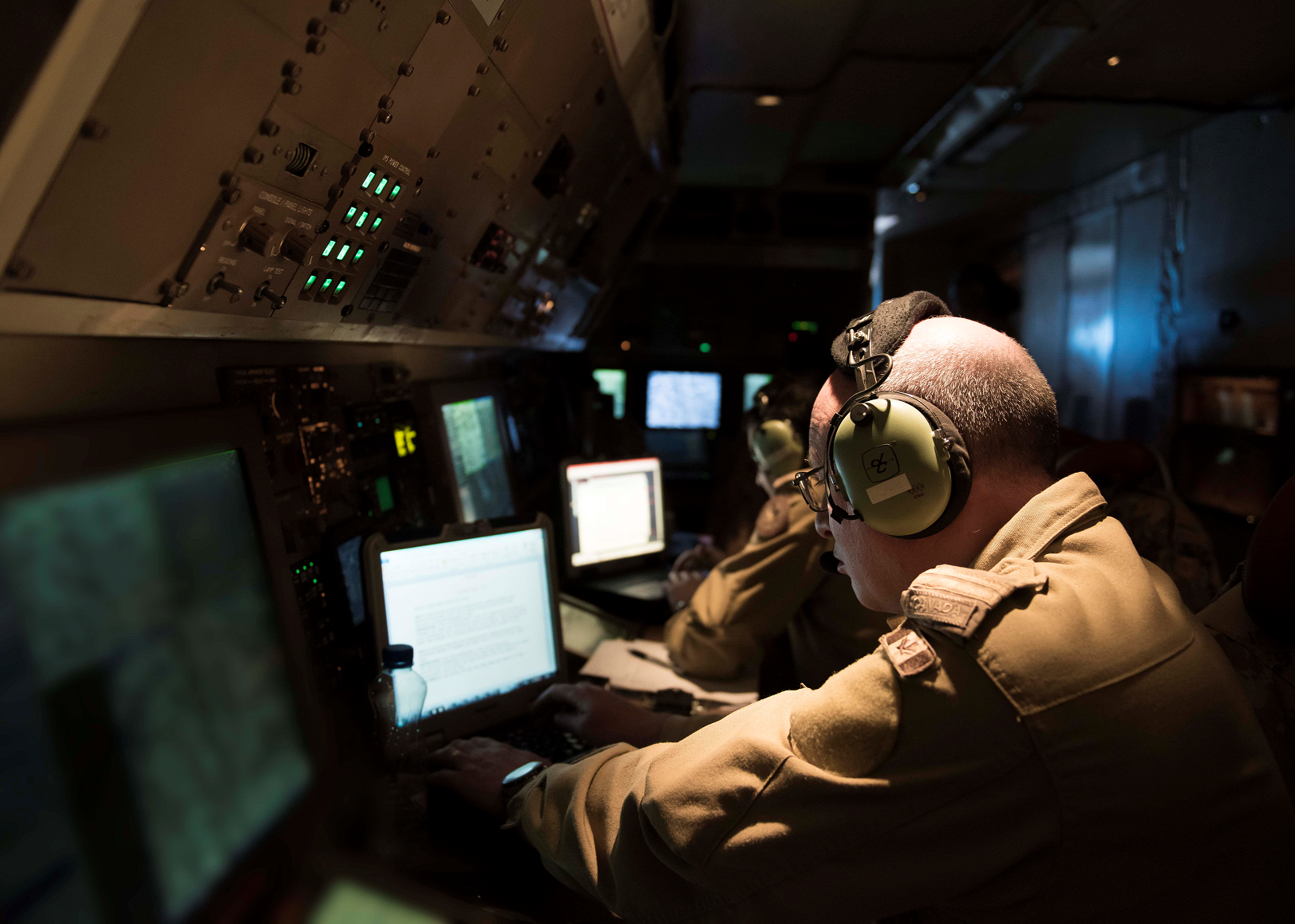 Des officiers de systèmes de combat aérien à bord d’un avion-patrouilleur, CP-140 Aurora consignent leurs observations lors d’une mission de reconnaissance dans le cadre de l’opération IMPACT, le 1er janvier 2017. (Photo : Op Impact, MDN)