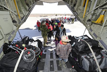Kashechewan, Ontario. 12 May 2014 – A CAF member helps to load passengers from the First Nations community of Kashechewan on a CC-130 Hercules aircraft to provide air evacuation assistance from localized flooding. Over eight flights were completed by the CAF during Operation LENTUS 14-01 to evacuate approximately 1,500 people from Kashechewan. (photo by Sgt Daren Kraus).