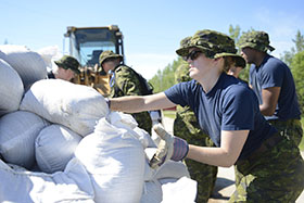 Lieutenant Marla Haring from 402 Squadron helps move sandbags in preparation for flooding across the Manitoba region in support of Operation LENTUS just outside St. Francois Xavier, July 7, 2014. Photo: Cpl Paul Shapka, 17 Wing Imaging