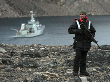 Baffin Island. 13 September 2015 – Warrant Officer Chagnon, the physician assistant onboard Her Majesty's Canadian Ship MONCTON, stands watch as predator patrol ashore in Baffin Island while the ship is at anchor in Albert Harbour, Nunavut during Operation QIMMIQ. (Photo: Corporal Felicia Ogunniya, 12 Wing Imaging Services, Shearwater, N.S)