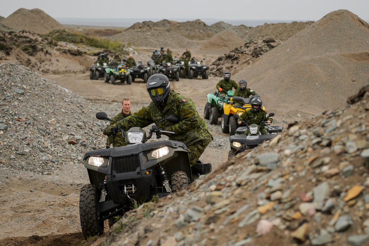 Deployed members from Operation NANOOK practice moving their centre of gravity while driving on steep terrain during an all-terrain vehicle driver safety course in the training area in Rankin Inlet, NU on August 15, 2017. Photo: Cpl Dominic Duchesne-Beaulieu