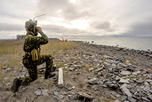 26 août 2016. Un orienteur marqueur du Royal 22e Régiment de Valcartier (Québec) assure la surveillance à l’arrivée des membres du Royal 22e Régiment au site de débarquement sur la plage à l’extérieur de Rankin Inlet, au Nunavut, le 26 août 2016, au cours de l’opération NANOOK. (Photo : Maître de 2e classe Class Belinda Groves, technicienne en imagerie de la Force opérationnelle)