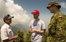Rick Steenweg représentant du ministère des Affaires étrangères, du Commerce et Développement Canada accompagné du major Frank Gould, membre des éléments de base de l’Équipe d'intervention en cas de catastrophe (EICC) discutent avec un représentant de village durant une patrouille de reconnaissance dans le cadre de l’aide apportée aux victimes du séisme au Népal par le gouvernement du Canada, le 2 mai 2015 Photo: Sgt Yannick Bédard, Caméra de combat des Forces canadiennes.