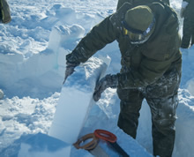Resolute Bay, Nunavut. 4 avril 2016. Un membre du 2e Bataillon du Royal Canadian Regiment découpe des blocs de neige pour construire un abri près de Resolute Bay, au Nunavut, en préparation pour l’opération NUNALIVUT le 4 avril 2016. (Photo : Cpl Parks, technicien en imagerie de la force opérationnelle)
