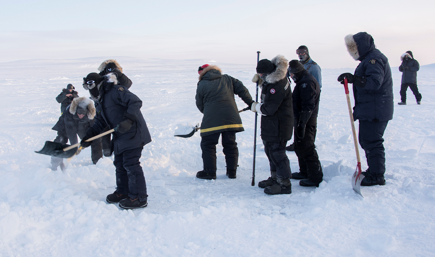 26 février 2017. Des plongeurs des Forces armées canadiennes et de la Gendarmerie royale du Canada déneigent la surface glacée pour pouvoir percer le trou de plongée au cours de l’opération NUNALIVUT 17, au Nunavut, le 26 février 2017. (Photo : Cpl Gabrielle DesRochers, Caméra de combat des Forces canadiennes)