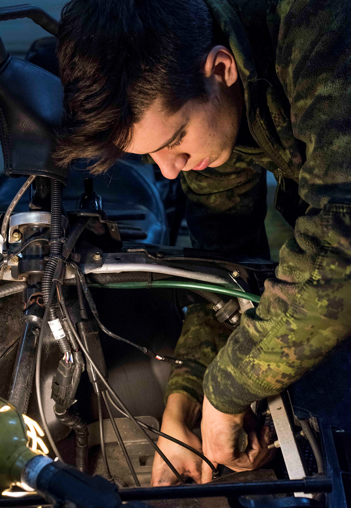 Corporal Kevin Potvin, a vehicle technician from 12e Régiment blindé du Canada replaces the carburetor of a Light Over Snow Vehicle during Operation NUNALIVUT 2017 in Hall Beach, Nunavut, February 27, 2017. (Photo: Sgt Jean-François Lauzé, Task Force Imagery Technician)
