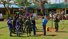 International Organization for Migration and UNICEF personnel explain their requirements to Canadian Armed Forces soldiers in order to build an evacuation shelter to let kids recover their classrooms that are currently used by typhoon Haiyan evacuees during Operation RENAISSANCE, in Pontevedra, Philippines on November 24, 2013. Photo: MCpl Marc-Andre Gaudreault, Canadian Forces Combat Camera IS2013-2006-089