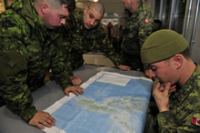 Private Sullivan, Master Corporal Beckwith, Corporal Brown and Corporal McGuire, members of the Disaster Assistance Response Team, study a map of the Philippine Islands that were ravaged by Typhoon Haiyan, at Canadian Armed Forces Base Trenton on November 13, 2013. Photo IS2013-3042-03: MCpl Patrick Blanchard, Canadian Forces Combat Camera
