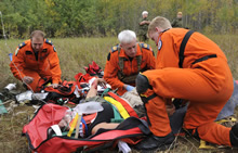 Gimli, Manitoba. 19 September 2013 – Master Corporal Donovan Ball (left), Sergeant Glen Hood (middle) and Master Corporal Curtis Schmidt administer first aid to a simulated casualty during the 2013 National Search and Rescue Exercise. (Photo: Pte Darryl Hepner, 17 Wing Winnipeg)