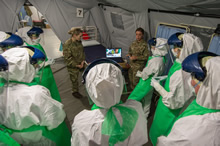 Strensall, Royaume-Uni. Le 11 décembre 2014 – Des membres de l’équipe médicale des Forces armées canadiennes regardent la vidéo de la prochaine étape de l’entraînement, au cours de l’entraînement préalable au déploiement en vue de l’opération SIRONA avec leurs homologues britanniques, au Centre d’instruction des services médicaux de l’armée, à Strensall, au Royaume-Uni. (Photo : Sgt Yannick Bedard, Caméra de combat des Forces canadiennes)