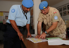 Pyla, Cyprus. 24 November 2008 – Captain Michael Solonynko (right), Operation and Information Analyst Officer for the UN HQ in Cyprus, discusses patrol routes to prevent overlapping patrols with UN Civilian Police Officer Nasir Ahmed from India, the Detachment Commander of Pyla Station. (Photo by MCpl Robert Bottrill, Canadian Forces Combat Camera) 