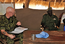 Yambio, South Sudan, 4 December 2012 – Commander Paul Earnshaw takes detailed notes as Captain Ngong Mawien, Deputy Commander of the Sudan People Liberation Army discusses changes in the village of Sakure. (photo by: Sgt Norm McLean, Canadian Forces Combat Camera)