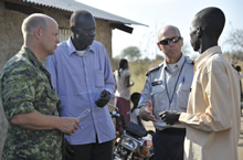 Juba, South Sudan, 7 December 2012 – Major Jan-Peter Hoekstra and Sergeant Robert Hagarty of the Ottawa police service speak with two men about the drilling of a well for a small school in Juba. (photo by: Sgt Norm McLean, Canadian Forces Combat Camera).