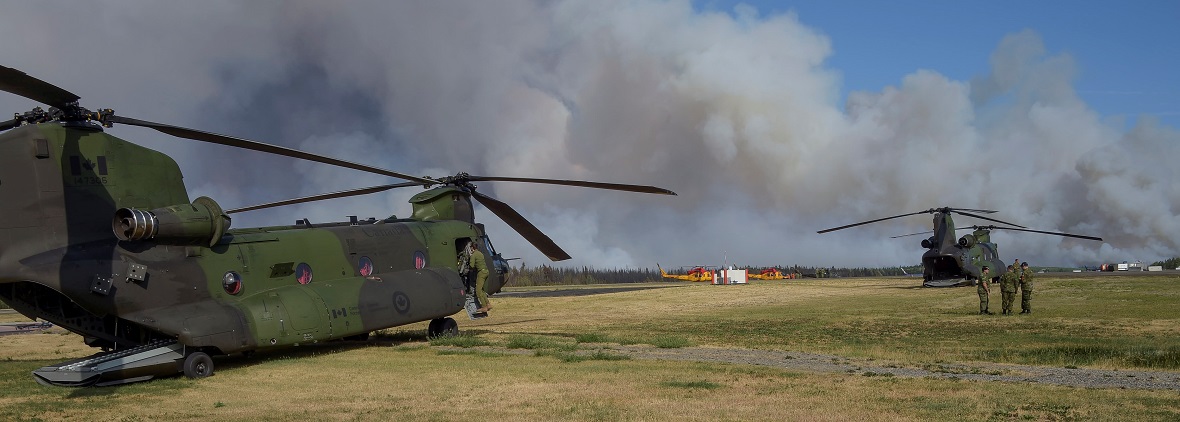 Des hélicoptères CH-147 Chinook et CH-146 Griffon sont en attente à l’aéroport de Williams Lake en vue d’une éventuelle évacuation de la région de Williams Lake au cours de l’opération LENTUS 17-04, en Colombie Britannique, le 15 juillet 2017. Photo : Cplc Gabrielle DesRochers, Caméra de combat des Forces canadiennes