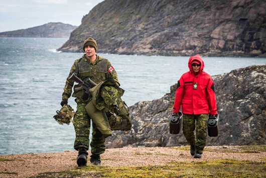 Iqaluit, Nunavut. Le 20 août 2018 - Le soldat Gabriel Zecchino, membre de la Compagnie Charles du 1er Bataillon, The Royal Canadian Regiment, et Moses Iqqaqsaq, membre des Rangers canadiens, sécurisent le périmètre, sur le littoral d’Iqaluit, au cours de l’opération NANOOK. (Photo : Avr Tanner Musseau-Seaward)