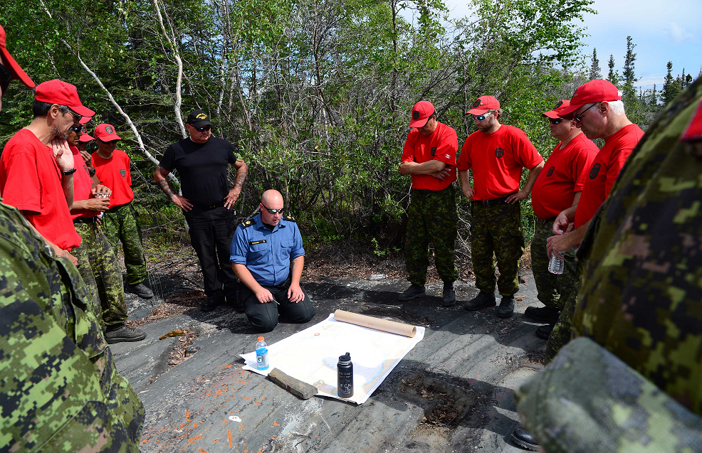 Petty Officer1st Class Eric Gindras (centre), from Canadian Forces Base Esquimalt explains the Search and Rescue scenario to members of 1 Canadian Rangers Patrol Group on the waters of Great Slave Lake near Yellowknife, Northwest Territories during Operation NUNAKPUT on July 11, 2016.   Photo: PO2 Belinda Groves, Task Force Imagery Technician
