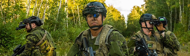 Four Canadian Armed Forces members in a forest wear Future Vision Enhancement Systems.